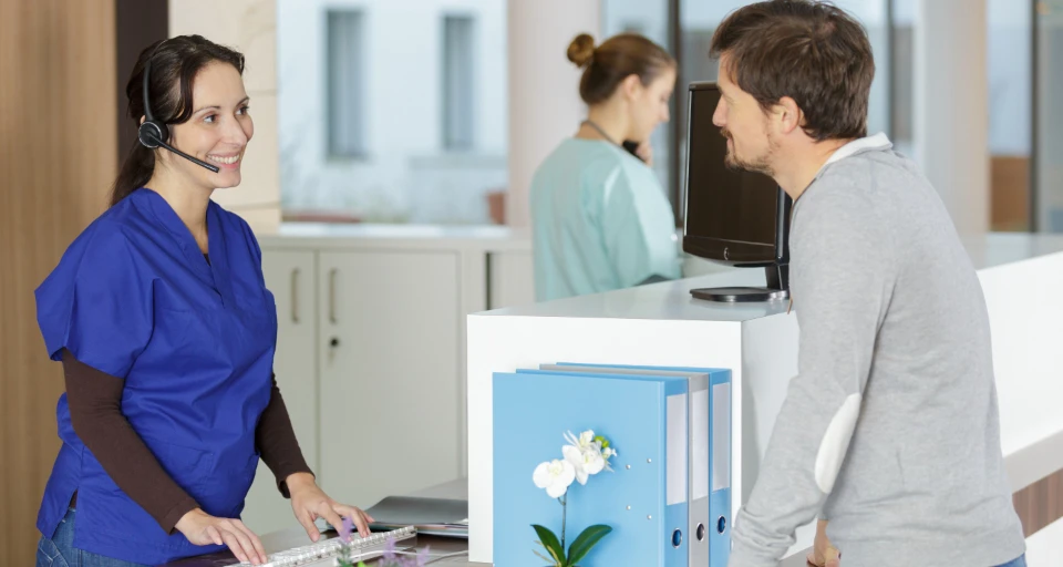 Dental Receptionist Speaking With Patient